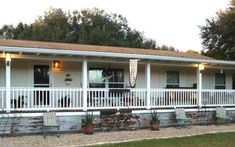 a white house with porches and chairs on the front