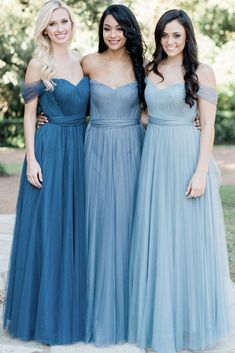 three women in blue dresses standing next to each other