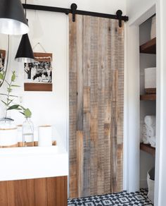 a bathroom with a wooden door and tiled floor