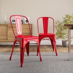 two red chairs sitting next to each other on top of a carpeted room floor