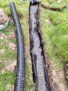 a pipe laying in the ground next to some grass