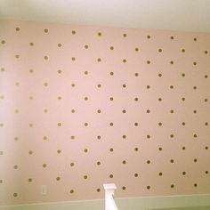 an empty room with polka dot wallpaper on the walls and stairs leading up to it