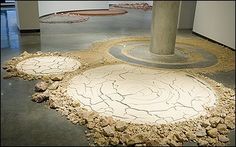 an art installation in the middle of a room with rocks and gravel on the floor