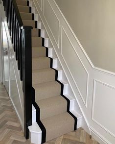 a staircase with carpeted steps and black handrails