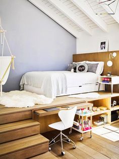 a loft bedroom with stairs leading up to the bed and storage space on the other side