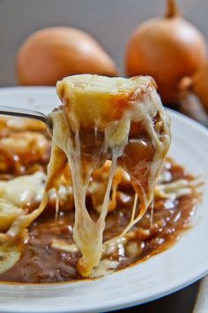 a spoon is lifting up some food from a plate