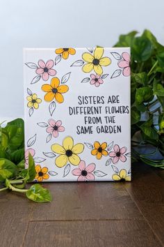 a card with flowers on it sitting next to some plants