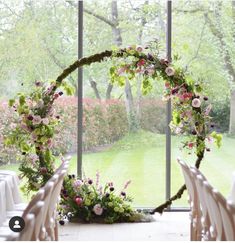 an outdoor wedding venue with flowers and greenery on the windowsill, chairs are set up in front of them