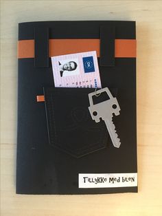 a card with a key in the pocket and some money sticking out of it's pocket