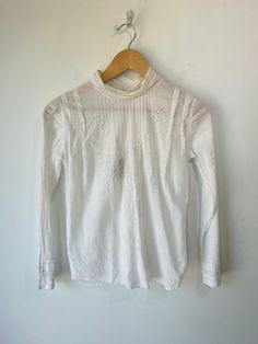 Victorian White Eyelet Shirt in really excellent condition considering it is antique. So cute! Featuring delicate lace on cuffs in a No wear visible aside from two small discoloration speckles on the collar (see photos). Unmarked size, fits many! May best fit xs/s. Wash separately in slightly warm water. Approximate Measurements: Length: 17" Underarm to underarm: 20" Eyelet Shirt, White Eyelet, Eyelet Lace, Warm Water, So Cute, Shirts Tops, Collar, Lace, Water