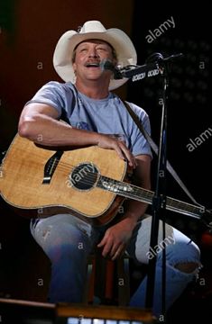 a man wearing a cowboy hat and holding a guitar