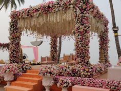 an outdoor wedding setup with flowers and greenery on the steps leading up to it