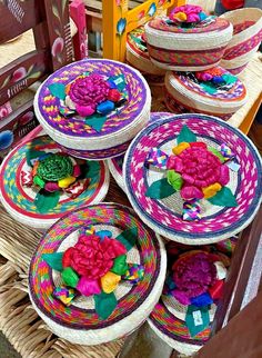 colorful baskets are stacked on top of each other in the shape of flower petals and ribbons