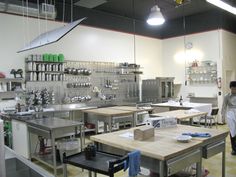 an industrial kitchen with lots of stainless steel appliances and tables in front of the counters