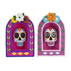 two colorful sugar skulls with flowers on them