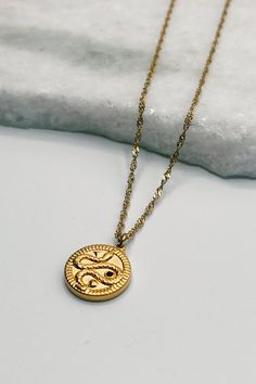 Image shows Samara Gold Snake Medallion Necklace against a white background. Necklace has a gold chain and a circle gold pendant that has a snake on it. Snake Motif, Faux Leather Purse, Gold Medallion, Studded Necklace, Snake Design, Medallion Necklace, Faux Leather Belts, Gold Snake, The Snake