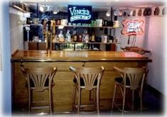 three wooden chairs sitting at a bar