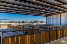 the inside of a building with wooden stalls and metal railings on both sides of it