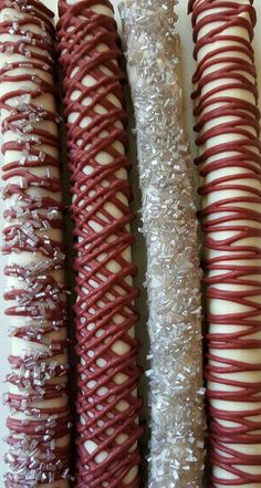 four different types of donuts with white and red icing on them sitting next to each other