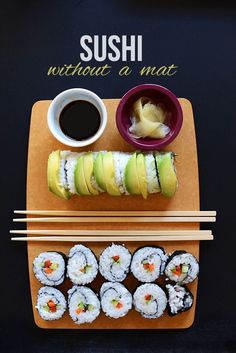 sushi with avocado and sauce on a cutting board next to chopsticks