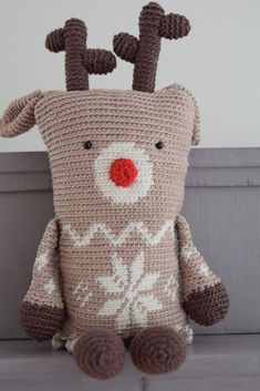 a crocheted stuffed animal sitting on top of a couch