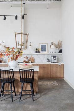 two black chairs sitting in front of a kitchen counter