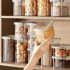 a person is picking up some food from a shelf