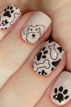 a person with white and black nail polish holding a dog paw print on their nails