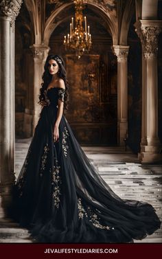 a woman in a black dress is posing for the camera with an ornate chandelier behind her