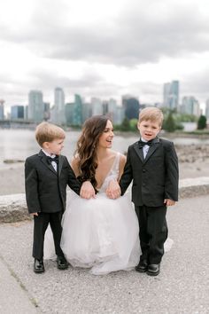 a couple of kids that are standing next to each other in front of some water