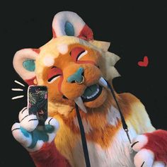 a stuffed animal is holding a cell phone