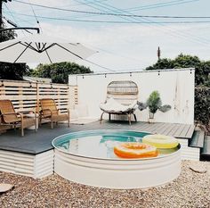 an outdoor patio with chairs, table and umbrellas on it's deck area