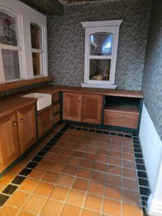 an empty kitchen with tile flooring and cabinets in the corner, next to a window