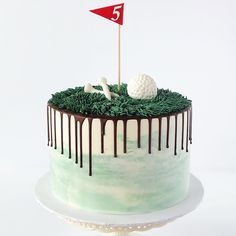 a golf themed birthday cake with green grass and white frosting on the top layer