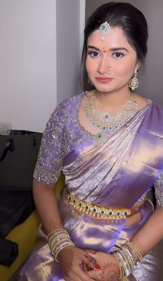 a woman in a purple sari with gold jewelry