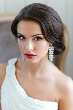 a woman in a white dress is looking at the camera and has red lipstick on her face