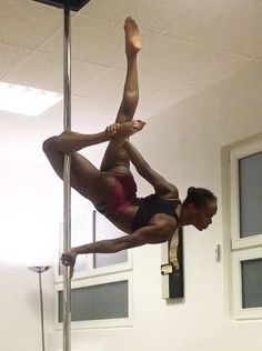 a woman is doing pole dancing on a pole