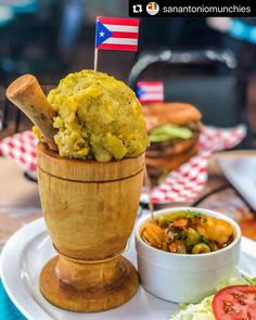 a wooden bowl filled with food on top of a white plate