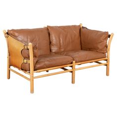 a brown leather couch sitting on top of a wooden frame