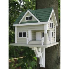 a white bird house on the side of a tree