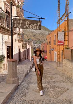 a woman is walking down the street in an old town