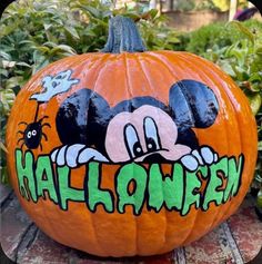 a mickey mouse pumpkin with the word halloween painted on it