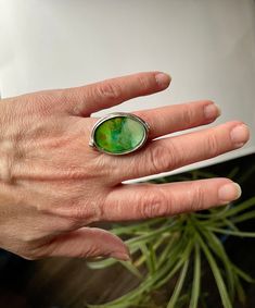 This unique statement ring has a tiny painting done in alcohol ink inside. The painting is then covered in resin for protection and shine. The ring is adjustable and made from antique silver coated brass.  Designed for wearing in the middle of the hand due to size. The bezel is about an inch long.  Great gift for an artist, someone who likes one-of-a-kind pieces, or yourself! Oval Green Enamel Ring Gift, Hand Painted Green Spiritual Jewelry, Spiritual Hand Painted Green Jewelry, Green Hand Painted Spiritual Jewelry, Adjustable Green Enamel Ring Gift, Green Adjustable Enamel Ring As A Gift, Adjustable Green Enamel Ring As Gift, Artistic Hand Painted Round Rings, Artistic Green Ring Jewelry