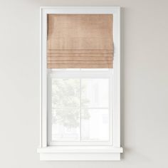 a white window with a tan roman blind