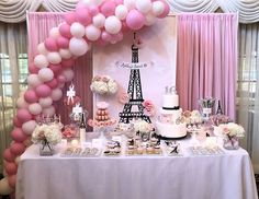 a table topped with lots of pink and white balloons next to a tall eiffel tower