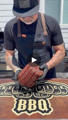 a man in an apron and hat working on a table