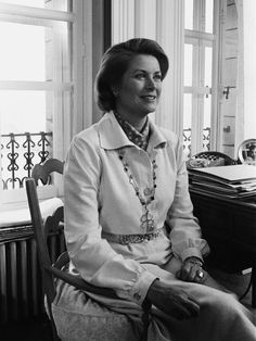 a woman sitting in a chair smiling at the camera