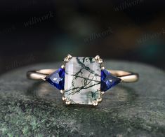 a white and blue ring sitting on top of a stone slab with gold trimmings