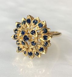 "Sapphire Ring, Blue Sapphire Ring, Sapphire Ring for Women, Sapphire Sunburst Ring, Vintage Sapphire Jewelry, Vintage Gold Ring, OOAK Ring A beautiful and intricately detailed never before owned vintage 14k yellow gold \" Sunburst\" ring featuring approximately 0.80 carats of round sapphires set within marquise shaped \"rays\". *Approximate ring weight: 6.19 grams * Ring size: 6 3/4 * Complimentary resizing is available up to 3 sizes larger or smaller than stated size." Cluster Yellow Gold Sapphire Ring, Yellow Gold Multi-stone Cluster Sapphire Ring, Yellow Gold Cluster Multi-stone Sapphire Ring, Cluster Sapphire Ring In Yellow Gold, Yellow Gold Sapphire Cluster Ring, Yellow Gold Cluster Sapphire Ring, Yellow Gold Sapphire Rings With Multi-stone, Yellow Gold Sapphire Cluster Ring With Center Stone, Yellow Gold Cluster Sapphire Ring With Center Stone