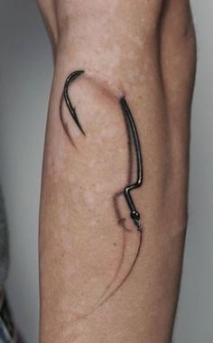 a tattoo on the arm of a person with an arrow in its left hand,